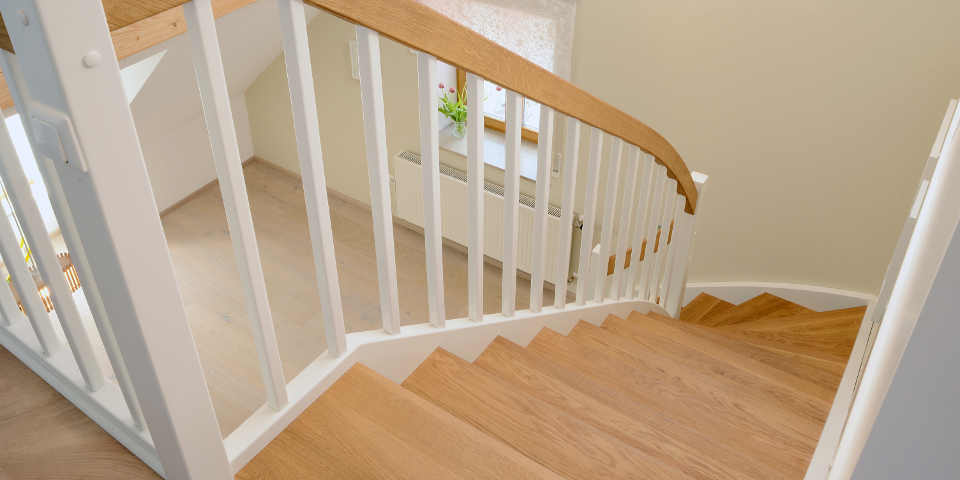 Treppe mit weißen Wangen und Holzstrufen